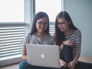 Two young women looking at a computer screen.