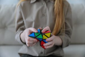 Girl indoors playing with rubiks cube
